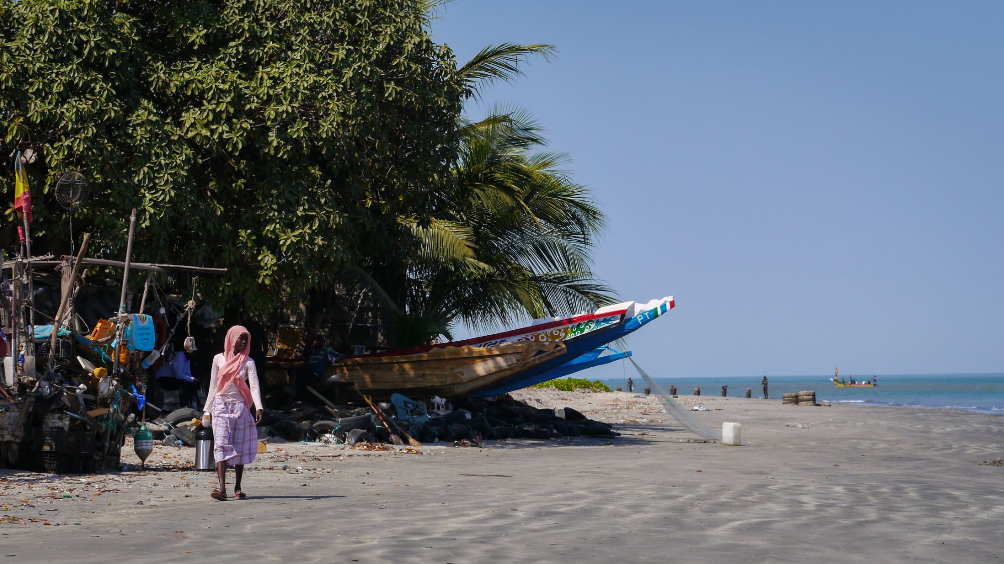 Fischerboot und Palmen am Strand in Gambia